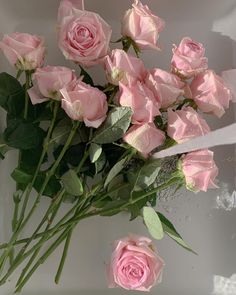 a bouquet of pink roses sitting on top of a table