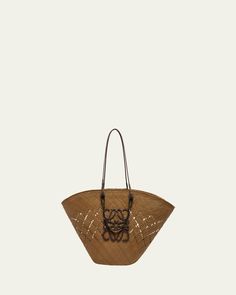 Loewe x Paula’s Ibiza basket tote bag in iraca palm and leather    Top handles    Shoulder straps    Can be worn as a top handle or shoulder bag    Open top with selftie closure    Exterior, Anagram accent at front    Approx. 13.3"H x 24.6"W x 7.8"D   Made in Spain Designer Basket Bags With Braided Handles, Designer Basket Bag With Braided Handles, Designer Bucket Bag With Braided Handles, Designer Natural Straw Bag For Daily Use, Designer Bucket Bag With Braided Handles For Shopping, Designer Basket Bag In Woven Leather, Designer Woven Leather Basket Bag, Designer Straw Tote Bag With Braided Handles, Designer Summer Shoulder Bag With Braided Handles