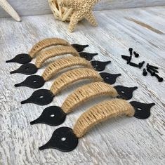 several black birds are lined up on a table next to some starfish and shells