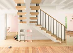 two chairs sitting in front of a stair case next to a wooden floor and white walls