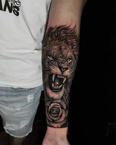 a man with a lion and rose tattoo on his arm