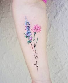 a tattoo with flowers on the arm and words written in cursive writing below it