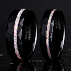 two black rings with white and pink glitter inlays on the inside of them