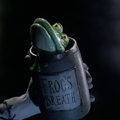 a frog sitting in a tin can with the words frogs breath on it's side