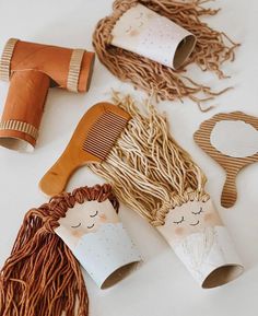 some craft supplies are laying out on the table together, including hairbrushes and combs