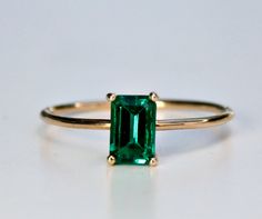 "This beautiful Emerald Gold Ring was handmade in Melt'm Jewelry Design Studio in California using 14k solid yellow gold band and 6x4mm emerald cut lab grown emerald stone. Emerald is featuring in 14k gold prong setting. DETAILS ABOUT THE RING, MATERIAL AND STONES Ring Band: 14K solid gold Ring Band size: 1 mm thick Gemstone: Lab grown Emerald Emerald size: 6mm x 4mm emerald cut Yellow gold or white gold options available from drop down menu. On the video shown 3 diamonds curved wedding band als Emerald Cut Solitaire Stackable Rings In 14k Gold, Classic Green 14k Gold Stackable Rings, Emerald Cut Gemstone Stackable Rings In 14k Gold, Fine Jewelry 14k Gold Solitaire Emerald Ring, Minimalist 14k Gold Emerald Ring With Prong Setting, Classic Emerald Gemstone Stackable Rings, Minimalist 14k Gold Emerald Cut Rings, 14k Gold Solitaire Emerald Ring, 14k Gold Solitaire Emerald Ring Fine Jewelry