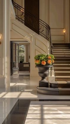 an elegant staircase with flowers in a vase on the bottom and another planter at the base