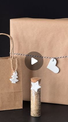 a brown bag with some white paper decorations hanging from it's side next to a bottle