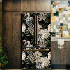 a kitchen with wooden cabinets and flowers on the refrigerator door, next to a potted plant