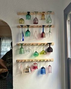 there are many different colored vases hanging on the wall next to each other in this room