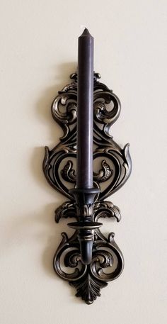 a wall mounted candle holder on the side of a wall