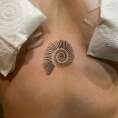 a tattoo on the back of a woman's stomach that has a spiral design