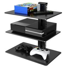 a black shelf holding two video game controllers and a wii controller on top of it