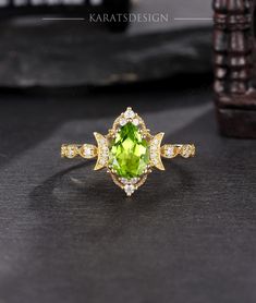 a ring with an oval cut green stone surrounded by small white and yellow diamond accents