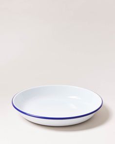 a white bowl with blue trim on the rim is sitting in front of a plain background