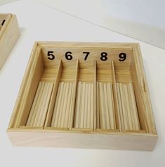 two wooden boxes with numbers on them sitting next to each other in front of one another