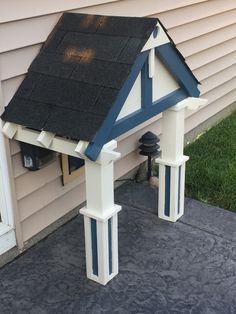 a white and blue house with a black roof