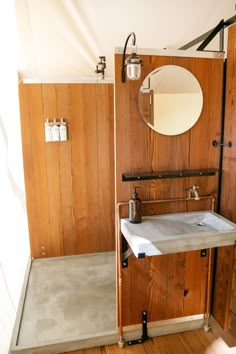 a bathroom with wood paneling and a mirror on the wall next to a sink