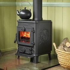 an old fashioned stove with a teapot on top and a basket next to it