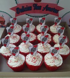 cupcakes with white frosting and red sprinkles in a box