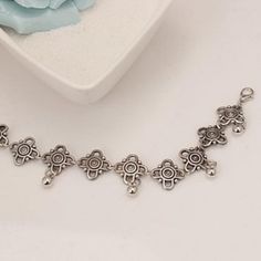 Lovely dainty floral-like charms dance around the ankle with small polished silver beads dangling down along the bottom. Features an adjustable clasp closure. Sold as one individual anklet. Measures approximately 8" with up to 4" of extension chain. Adjustable Metal Anklets Nickel Free, Silver Dangle Anklets, Silver Alloy Anklet As Gift, Elegant Silver Alloy Anklets, Adjustable Silver Anklets For Festivals, Adjustable Metal Dangle Anklets, Silver Dangle Metal Anklets, Adjustable Silver Dangle Anklets, Adjustable Metal Charm Bracelet With Flower Charm