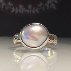 "Silver Pearl ring. White Pearl Ring. Solitare Pearl Ring. Unique Pearl Ring. Modern Pearl Ring. Girlfriend gift. Beautifully Handcrafted upcycled bezel set Natural Cultured Pearl set on a etched floral hand forged solid sterling silver band.. This unique yet very versatile ring is a size 8 but is available in any size with a very similar Pearl and is sure to be your go to accessory for all your fresh spring looks. Please note. The ring in the photo is available in a size 8 , the stunning Pearl Ring Pearl Modern, Jewelry Trending, Natural Pearl Ring, White Pearl Ring, Trending 2024, Bijoux Art Nouveau, Commitment Rings, Silver Pearl Ring, Healing Crystal Ring