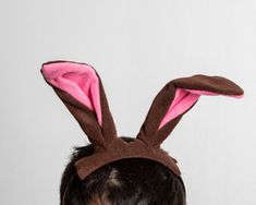 a man wearing a brown and pink bunny ears headband on top of his head