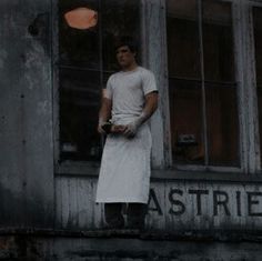 a man standing in the window of an old building