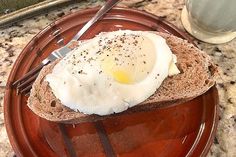 an egg is sitting on top of a piece of bread with a knife and fork