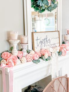 a mantel decorated with flowers, candles and a sign that says together on it