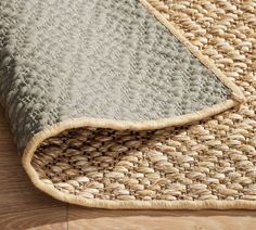 a close up of a rug on the floor with wood and woven material in it