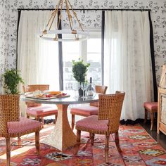 a dining room table with four chairs and a chandelier hanging from the ceiling