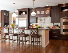 a kitchen with wooden floors and dark wood cabinets