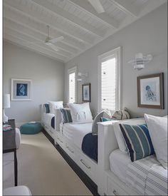 an image of a bedroom with white furniture and blue accents on the walls, along with two twin beds