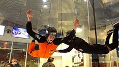 a man flying through the air while riding a skateboard in front of other people