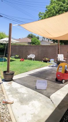 a small toy car is parked on the concrete in front of an outdoor patio area