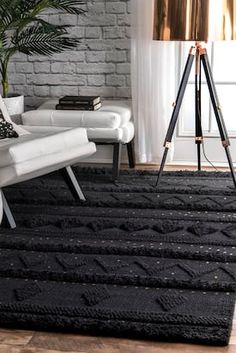 an image of a black rug on the floor with a tripod in front of it