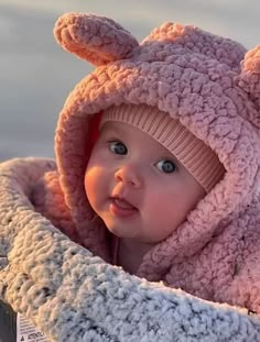 a baby wearing a pink bunny hat and scarf