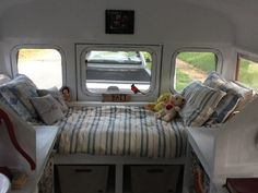 there is a small bed in the back of a bus with stuffed animals on it