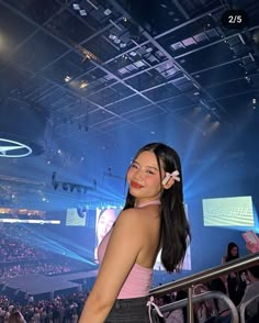 a woman standing in front of a crowd at a convention or event with her hand on her hip