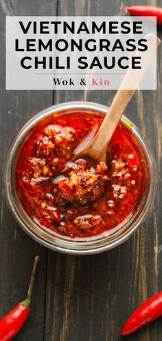 a bowl filled with chili sauce next to red peppers