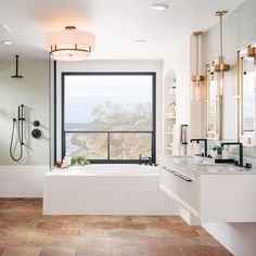 a bathroom with a large window overlooking the ocean