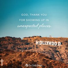 the hollywood sign is on top of a hill with hills in the background and a blue sky above it