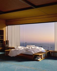 a large bed sitting in the middle of a living room next to a book shelf