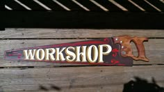 there is a sign that says workshop on the side of a wooden bench with a pair of scissors