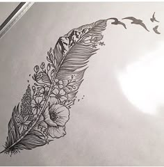 a drawing of a feather with flowers and birds flying by on top of the paper