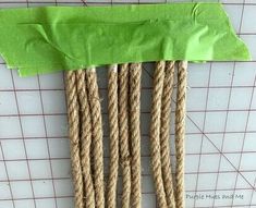 several pieces of rope are tied together on a piece of green paper and placed next to each other