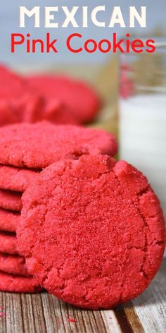 mexican pink cookies are stacked on top of each other with a glass of milk in the background