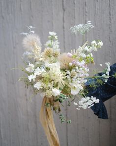 a bouquet of white flowers in front of a wooden wall