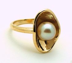 Classy Minimalist Ring in 14KT yellow gold, stunning unique design,the pearl is a natural freshwater pearl 5mm round,slightly blemished with high luster Details of the ring: Metal: 14KT yellow gold Center name: Pearl Center type: Freshwater Remarks: Natural-no treatment Clarity: Slightly Blemished Color: White Size: 5mm pearl Gram weight: 3-4 grams Width: third of an inch in height and width Size of the ring on the picture: 7 This is a made to order ring and will take approximately 1 week to com Golden Pearl Ring, Fine Jewelry Yellow Gold Pearl Ring With High Luster, Yellow Gold Pearl Ring With High Luster, Modern Yellow Gold Pearl Ring For Anniversary, Oval Yellow Gold Pearl Ring With High Luster, Yellow Gold Oval Pearl Ring With Polished Finish, Oval Pearl Ring In Yellow Gold With High Luster, 14k Yellow Gold High Luster Pearl Ring, 14k Gold Pearl Ring With High Luster